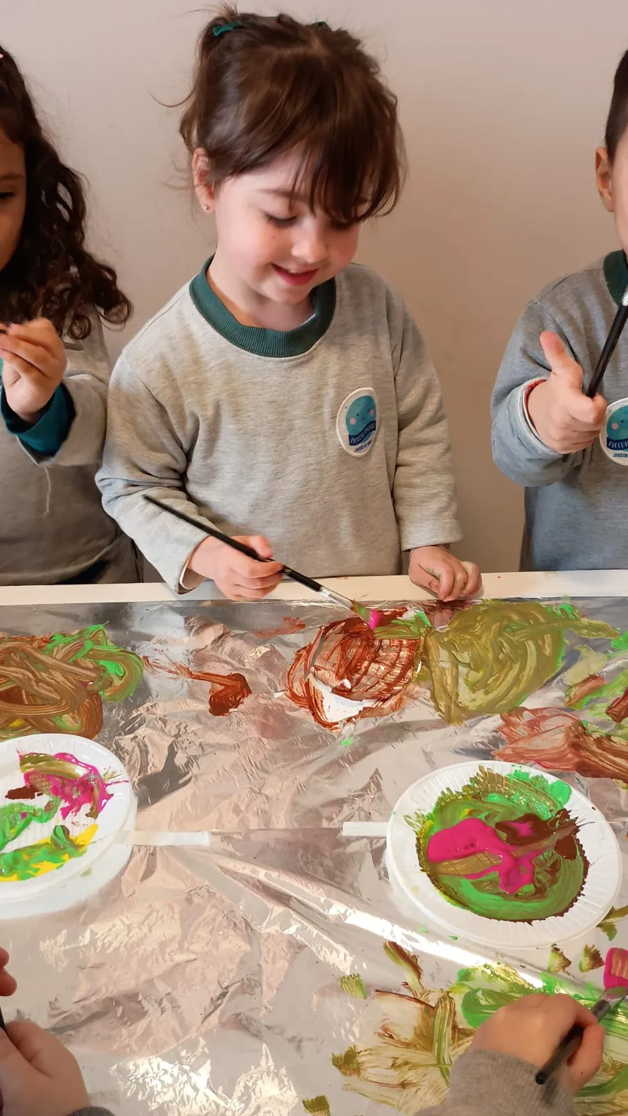 Chicos con el conjunto de gimnasia de Piccolo Mondo pintando en la sala