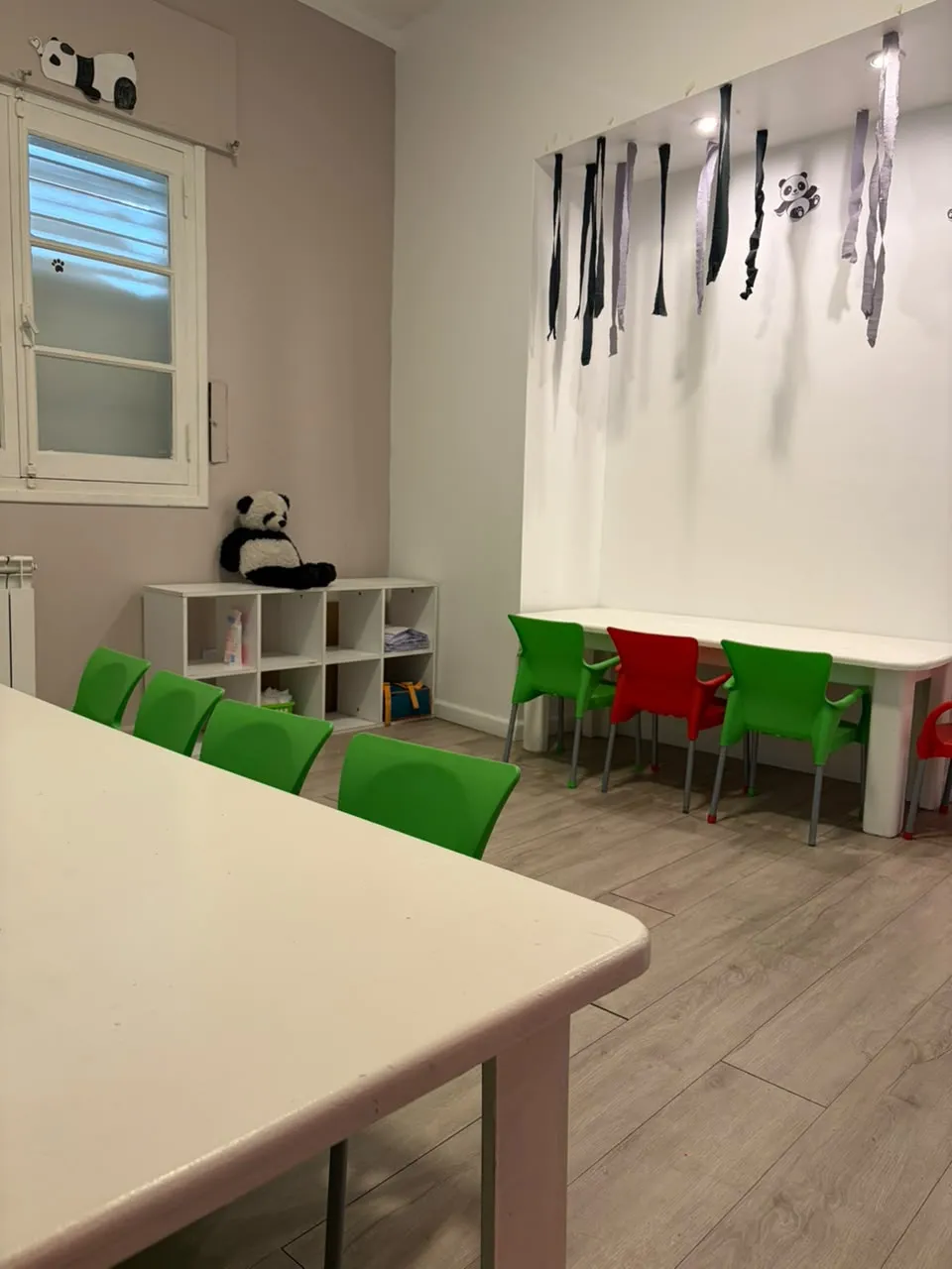 Sala de la sede Tiburcio Benegas, con sillas verdes y rojas alrededor de la mesa